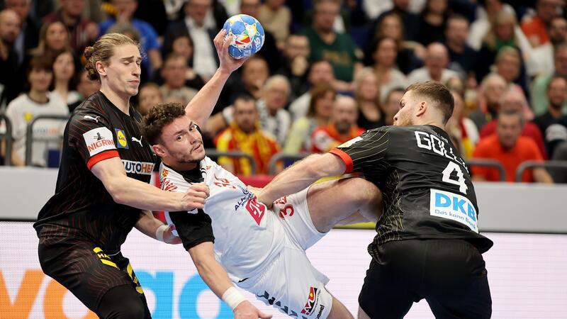 Kanzler Scholz jubelt: Handballer stehen in der Hauptrunde Die deutsche Defensive hält: Tomislav Jagurinovski aus Mazedonien (M) bleibt an Juri Knorr (l) und Johannes Golla (r) hängen.