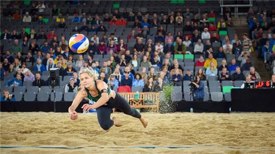 Die deutsche Spielerin Laura Ludwig springt im Gruppenspiel gegen ein brasilianisches Team dem Ball hinterher.