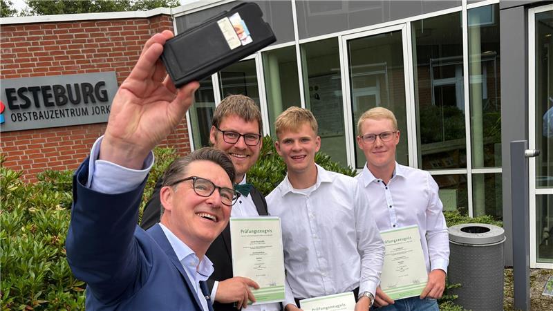 „Außergewöhnlich“: 59-jähriger Buchhalter schult noch mal auf Obstbau um Die drei Jahrgangsbesten Jacob Hauschild, Levi-Hinrich Schleßelmann und Luca Dehmel (hinten) bei einem Selfie mit Sparkassen-Vorstand Michael Senf.