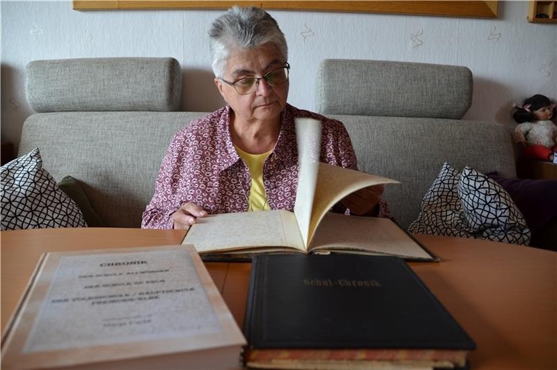 Die ehemalige Konrektorin blättert in der Chronik , für die sie Sütterlin und die deutsche Schreibschrift entziffern musste. Foto: Helfferich