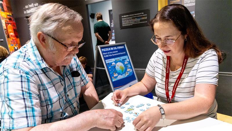 Weltreise in 16.000 Teilen - Riesiges Puzzle im Klimahaus Die ersten Besucher versuchen sich an dem überdimensionalen Puzzle.