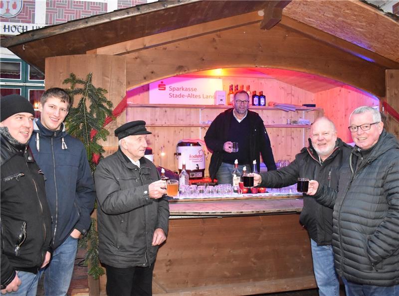 Die ersten Gäste am Punschstand der Werbegemeinschaft Jork stoßen mit Bürgermeister Gerd Hubert (rechts) an. Foto Vasel