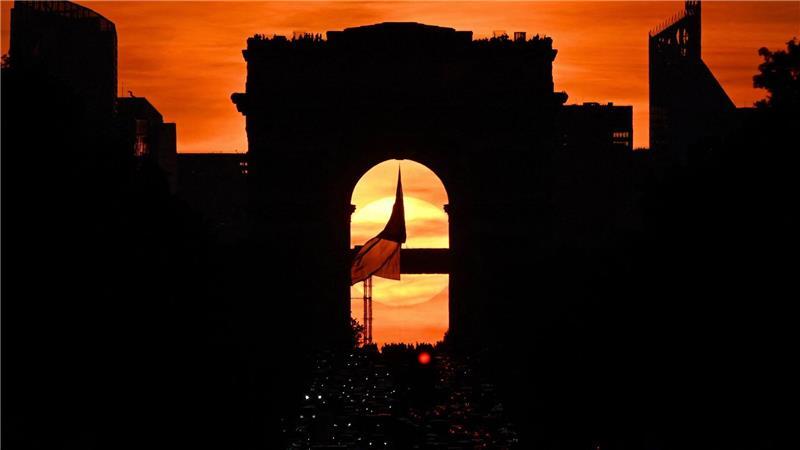 Die französische Nationalflagge weht unter dem Arc de Triomphe auf der Avenue des Champs Elysees während des sogenannten „Paris Henge“-Phänomens.
