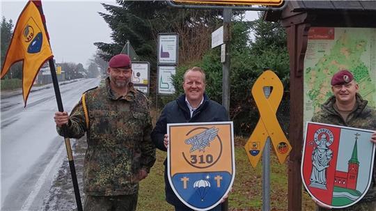 Die gelben Schleifen zeigen die Verbundenheit. Zum 25-jährigen Bestehen der Partnerkompanie brachten (von links) Kompaniechef Major Gerhards, Jörn Keller (Samtgemeindebürgermeister Sittensen) und Oberstabsfeldwebel und Kompaniefeldwebel Wellmann das Symbol an.
