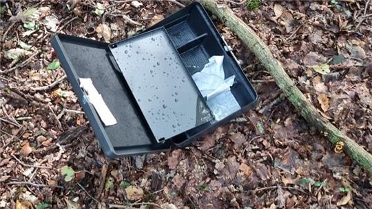 Die geplünderte Geldkassette am Fundort im Wald nahe der Straße Im Mühlenfeld.