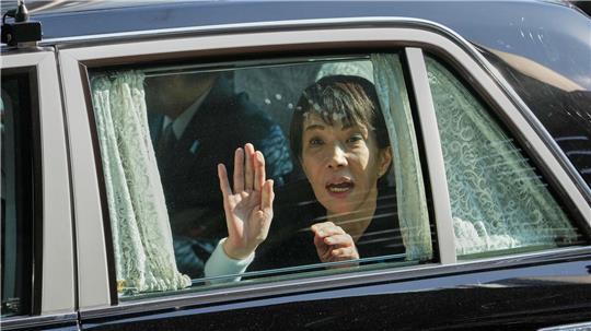 Die japanische Premierministerin Sanae Takaichi winkt von ihrem Fahrzeug aus.