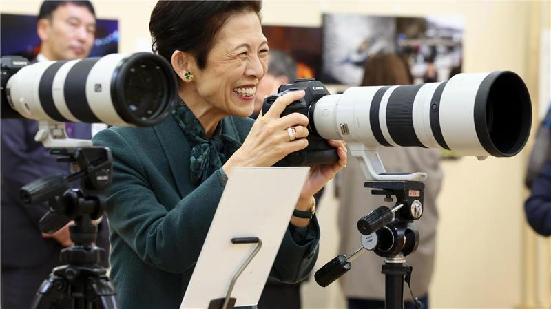 Die japanische Prinzessin Hisako probiert eine professionelle Kamera aus.