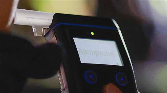 Die Polizei misst den Atemalkoholgehalt eines Autofahrers mit einem Alkoholtester, um festzustellen, ob er möglicherweise unter Alkoholeinfluss steht.