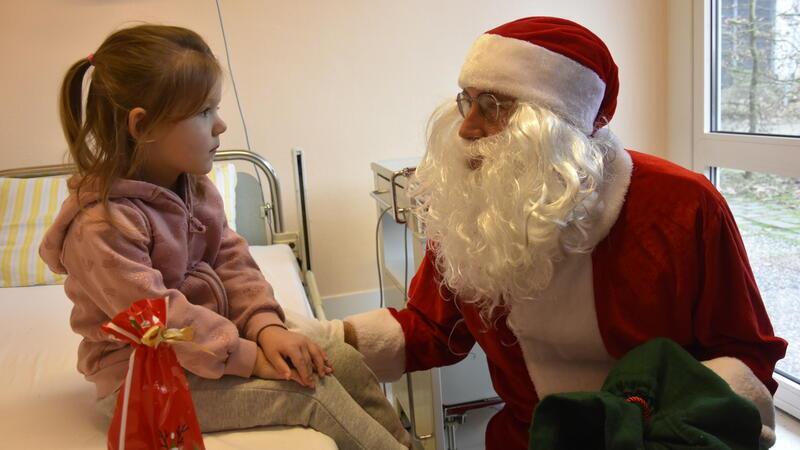 Der Weihnachtsmann zu Besuch auf der Stader Kinderstation Die kleine Mailyn schaut den Weihnachtsmann noch etwas skeptisch an.