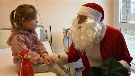 Die kleine Mailyn schaut den Weihnachtsmann noch etwas skeptisch an.