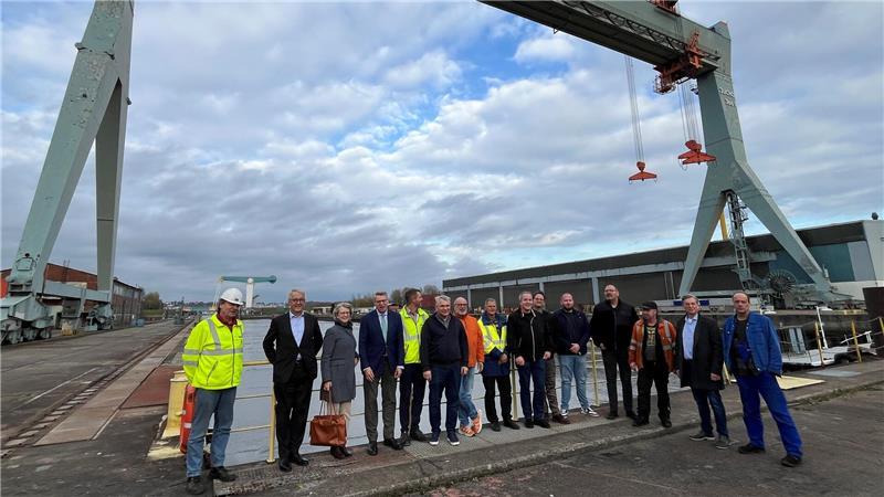 Die letzten Mitarbeiter der Pella Sietas-Werft im Schatten des Portalkrans mit dem Team des Insolvenzverwalters.