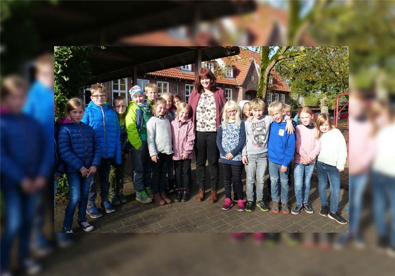 Die neue Schulleiterin Nina Heptner mit einem Teil ihrer dritten Klasse auf dem Schulhof in Estorf. Foto: Eidtmann