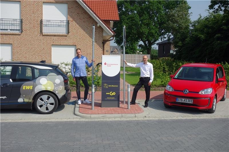 Die offizielle Inbetriebnahme der E-Ladesäule erfolgte durch Rolf Wellbrock vom EWE Vertrieb und Stefan Moje (rechts), Filialdirektor Horneburg für die Kreissparkasse Stade. Foto: EWE