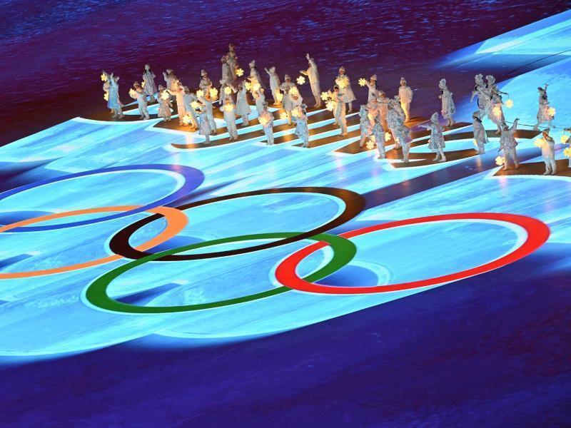 Die olympischen Ringe erstrahlen während der finalen Zeremonie vor den Artisten. Foto: Peter Kneffel/dpa