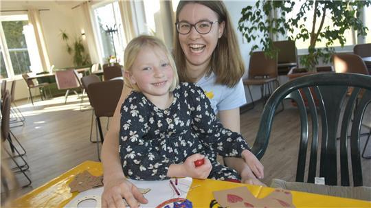 Die siebenjährige Marit bastelt mit Hilfe von Franziska Kaiser ein Mobile.