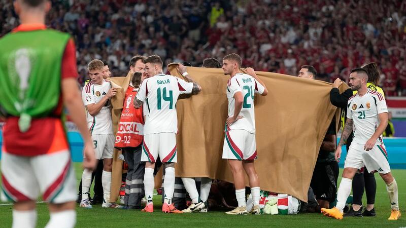 Europameisterschaft: Varga-Unfall weckt furchtbare Erinnerungen Die ungarischen Spieler halten einen Sichtschutz, während Stürmer Barnabas Varga behandelt wird.