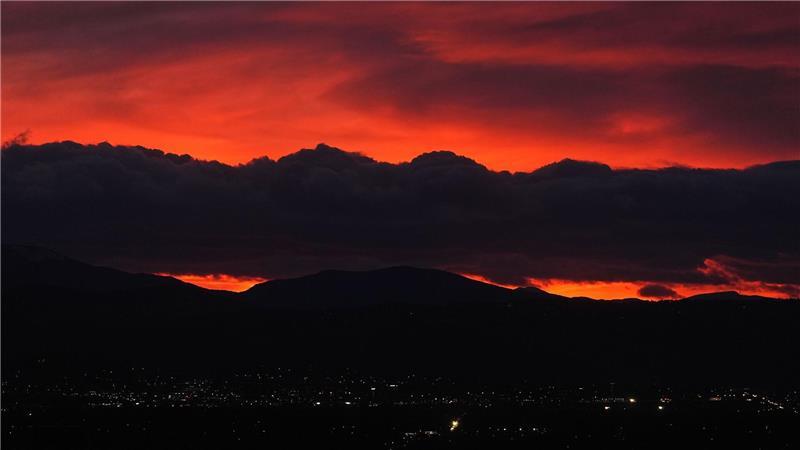 Die untergehende Sonne beleuchtet eine Wolkenbank, die über den Rocky Mountains schwebt, während ein Sturm über die Front Range von Colorado fegt.