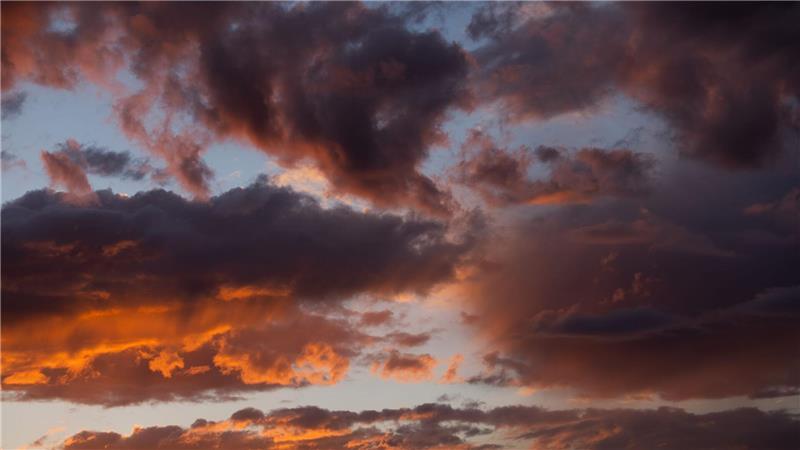 Bilder des Tages Die untergehende Sonne lässt die Wolken über Köln rötlich schimmern.