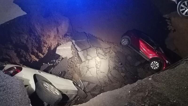 Riesiges Erdloch in Rom verschlingt zwei Autos Die zwei geparkten Autos liegen in dem Erdloch.