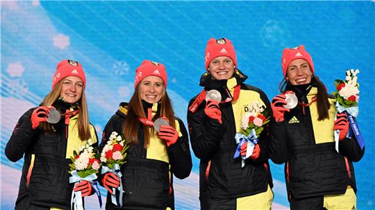 Die zweitplazierten Katherine Sauerbrey (l-r), Katharina Hennig, Victoria Carl und Sofie Krehl aus Deutschland feiern mit ihren Silbermedaillen auf der Bühne. Foto: Angelika Warmuth/dpa