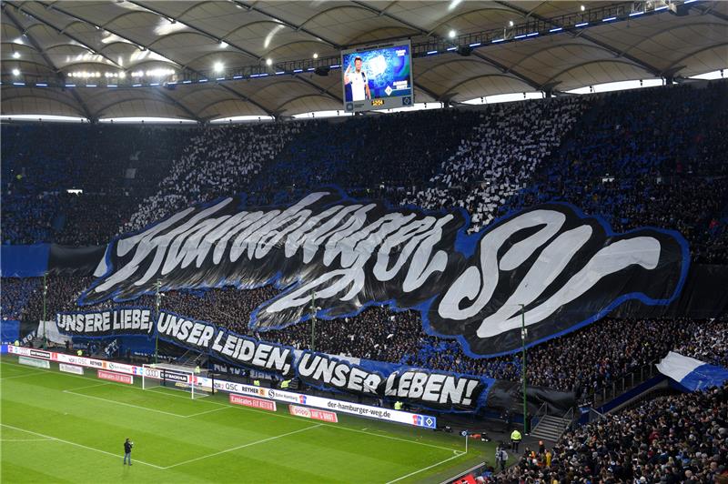 Die Fans des Hamburger SV halten ein großes Transparent und ein Banner mit der Aufschrift „Unsere Liebe, unser Leiden, unser Leben“. Foto: Daniel Bockwoldt/dpa