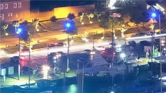 Diese Aufnahme entstand an einem Freitagabend im Juni um kurz vor Mitternacht - und zeigt regen Betrieb auf dem Parkplatz am Hafen. Die hellen Lichtstreifen stammen von schnell fahrenden Fahrzeugen. Etwa ein Dutzend Autos steht dort mit eingeschalteten Scheinwerfern.