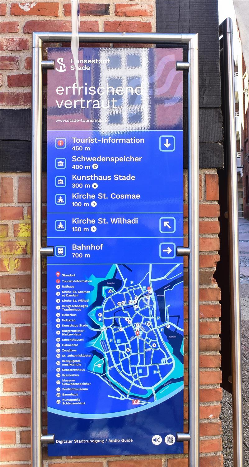 Eine blaue Infotafel mit Wegbeschreibungen in der Stader Altstadt.