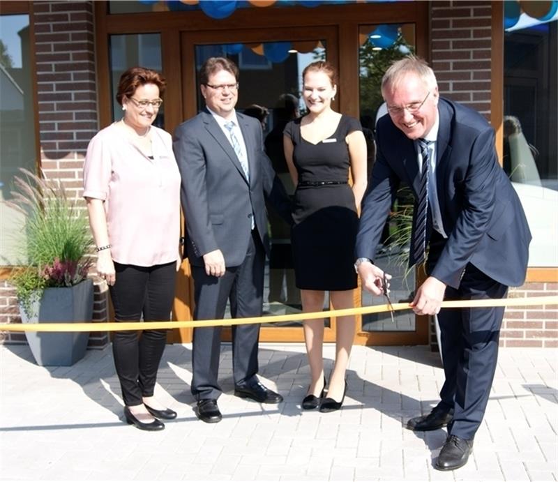 Dietmar Bruss zerschneidet das Band und die Mit- arbeiter (von links) Hilke Grell, Uwe Tiedemann und Carolin Stripling freuen sich über die neuen Geschäfts- räume der Volksbank Kehdingen in Freiburg. Foto Hamann