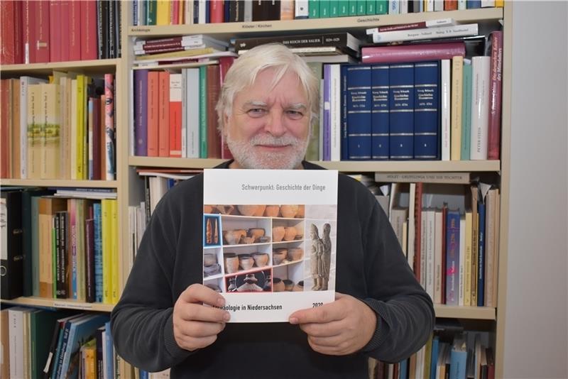 Dietrich Alsdorf hält das Archäologie-Jahrbuch in Händen. Foto: Vasel