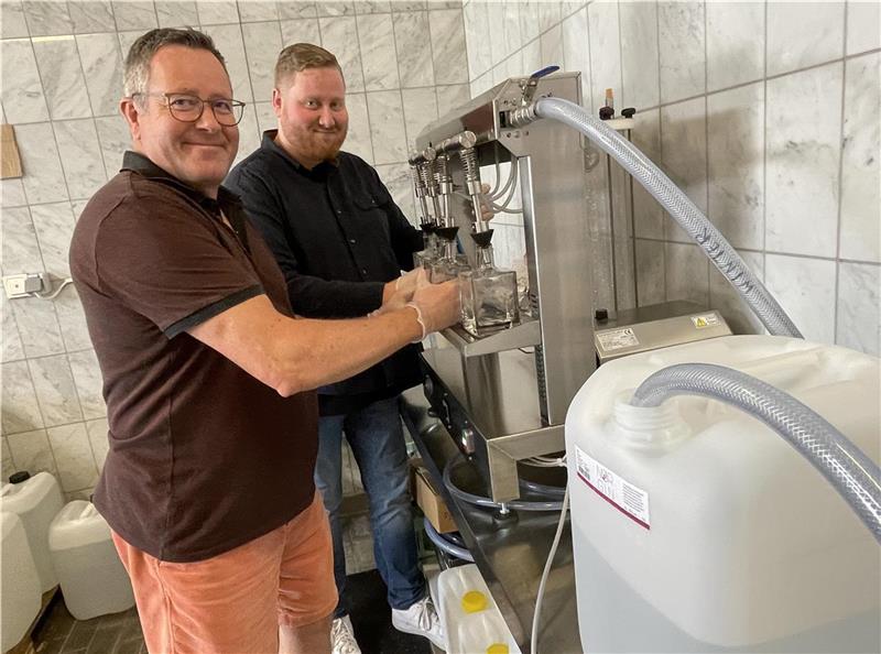 Dirk Vowinkel und sein Sohn Daryn an der Abfüllmaschine. Sie schafft 600 Flaschen in der Stunde. Foto: Glückselig