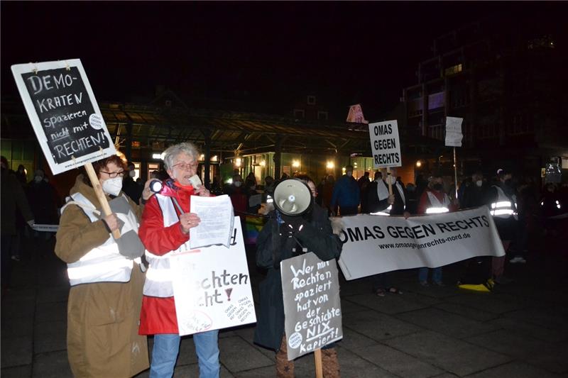 Dörte Schnell (rote Jacke) von den „Omas gegen Rechts“ ruft auf dem Platz Am Sande dazu auf, niemals mit den Rechten zu demonstrieren. Foto: Helfferich