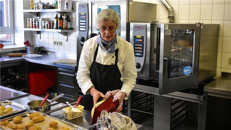 Fluffys, Fleisch und Salat: So essen Schüler in Stade und Fredenbeck Dörte Wellm, 2. Vorsitzende des Mensavereins Geestlandschule, holt hier ein Brot aus der Brotbackform und unterstützt die Schüler beim Kochen.