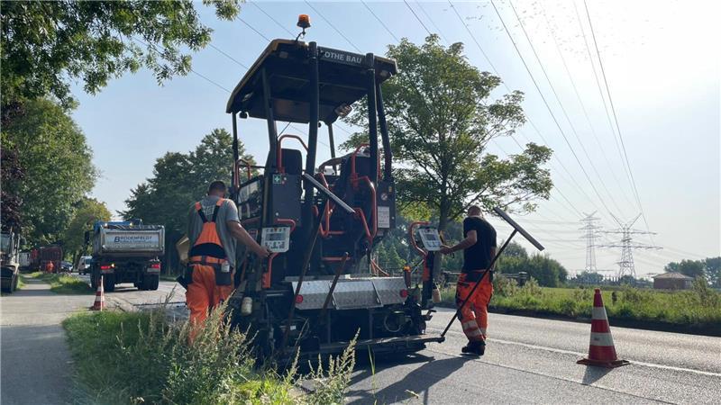170 Grad: So gehen Straßenbauarbeiter in Stade mit der Hitze um Zwei Bauarbeiter bedienen einen Aspahltfertiger.