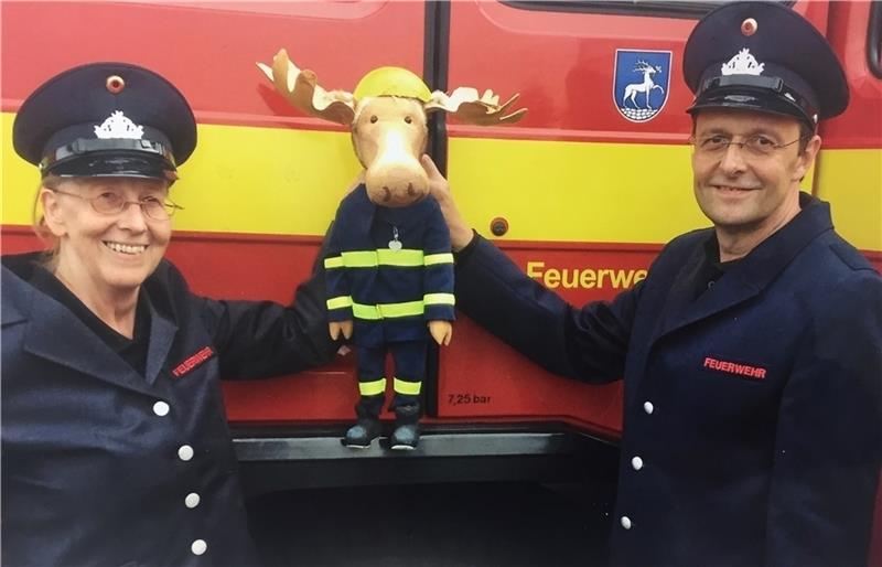 Dorothee Wellfonder und Wolfgang Kaup-Wellfonder mit der Figur Finn, dem Feuerwehrelch , an einem echten Einsatzfahrzeug. Foto: Wodo Puppenspiel