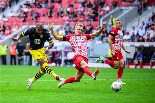 Dortmunds Donyell Malen (l) sorgte mit seinem Tor für den zwischenzeitlichen 2:2-Ausgleich des BVB in Freiburg.