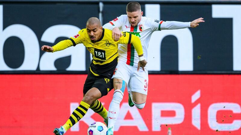 „Definitiv zu wenig“: BVB zurück in Bundesliga-Tristesse Dortmunds Donyell Malen (l) versucht den Ball vor Augsburgs Mads Pedersen (r) zu behaupten.