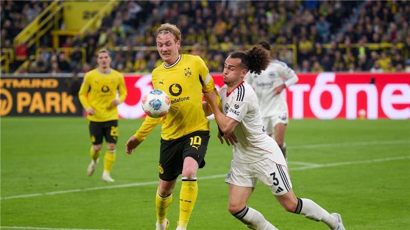 Dortmunds Julian Brandt im Duell mit Frankfurts Arthur Theate. 