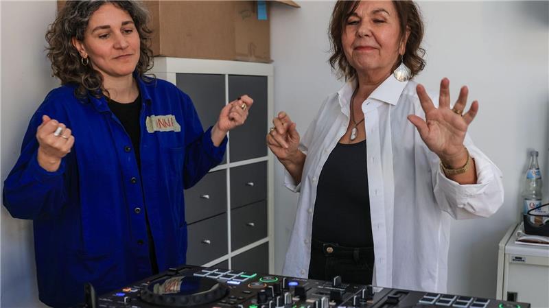 Dozentin Anna Cainelli (links) hilft DJ-Schülerin Ingrid Jatho, das Lied „Bauch Beine Po“ zu spielen.
