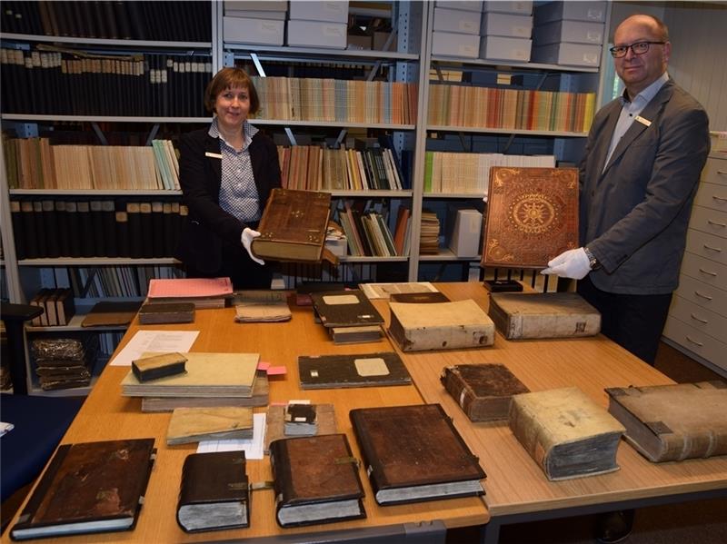 Dr. Christian Deggim präsentiert das Andachtsbuch der Domina vom Kloster Lilienthal aus dem 14. Jahrhundert, Bürgermeister Sönke Hartlef die großformatige „ Goldene Bibel “.