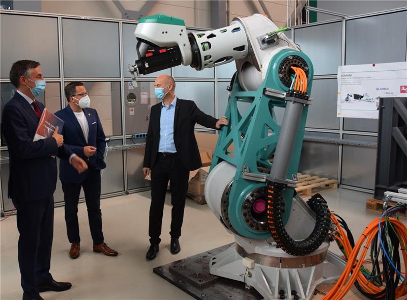 Dr. Dirk Niermann vom Fraunhofer-Institut in Stade erklärt David McAllister (links) und Kai Seefried einen Hochpräzisionsroboter . Foto: Strüning