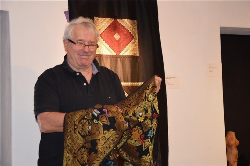Dr. Elmar Müller mit zwei Textil-Stücken – einem Songket und einem Wandbehang – von denen er sich „auf keinen Fall“ trennen würde. Foto: Battmer