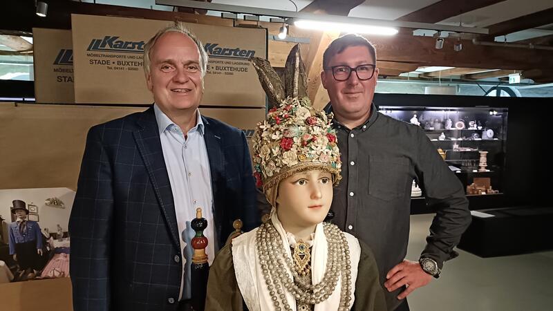 Dr. Hans-Eckhard Dannenberg (links) und Dr. Sebastian Möllers mit einer Puppe in Altländer Tracht aus dem Heimatmuseum.