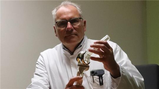 Dr. Jörg Franke zeigt ein Kniegelenk. Knieverletzungen sind häufig im Sport.