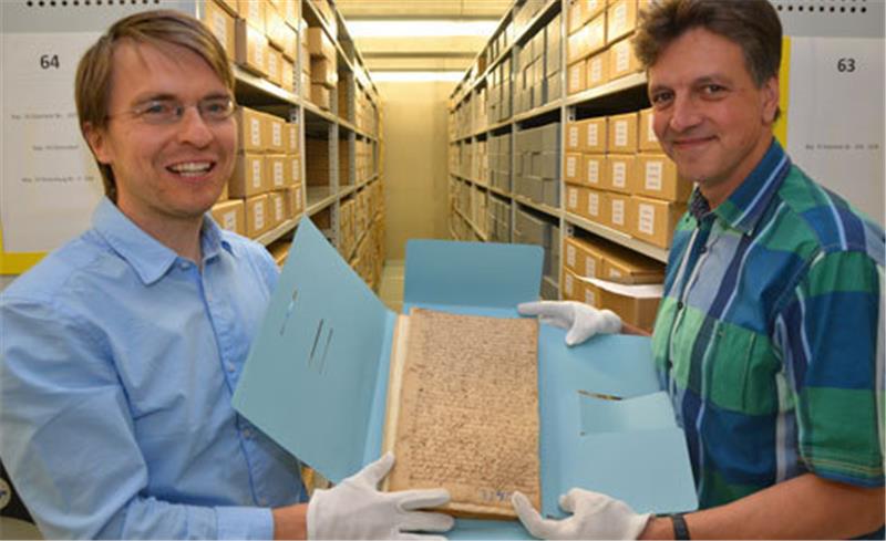 Dr. Jörg Voigt (links) und Dr. Thomas Bardelle zeigen eine Archivakte.
