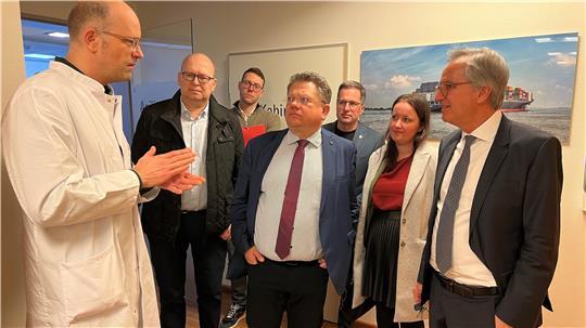 Dr. Markus Herrmann führt den Besuch um Minister Dr. Andreas Philippi (Mitte) durch die Strahlentherapie.