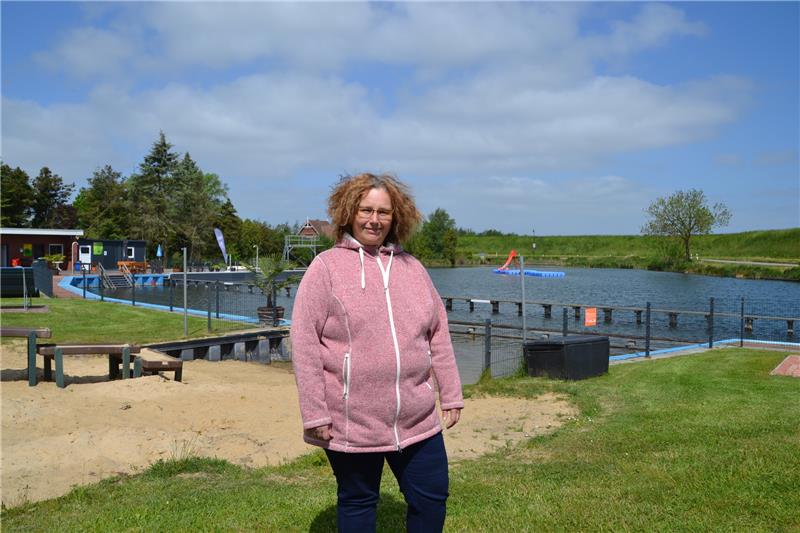 Drei Tage vor Saisoneröffnung steht Schwimmmeisterin Yvonne Meyer noch mit dicker Jacke vor der Krummendeicher Kuhle. Ab Pfingstsonntag können sich die Badegäste wieder ins Naturfreibad stürzen. Foto: Helfferich