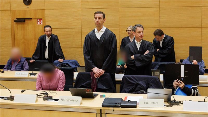 Drei der zehn Angeklagten sitzen am ersten Prozesstag im Landgericht Bielefeld neben ihren Verteidigern. 