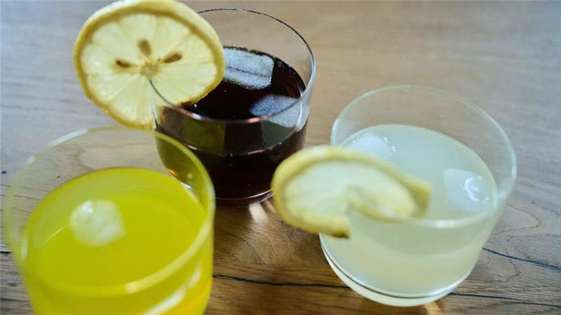 Drei unterschiedliche Arten Softdrinks stehen auf einem Tisch