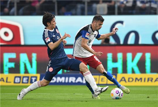 Düsseldorfs Ao Tanaka (l) und Hamburgs Laszlo Benes kämpfen um den Ball. Foto: Daniel Bockwoldt/dpa