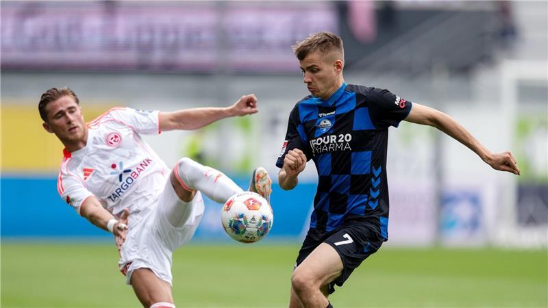 Düsseldorf feiert in Überzahl den ersten Saisonsieg Düsseldorfs Tim Rossmann (l) und Paderborns Filip Bilbija kämpfen um den Ball.